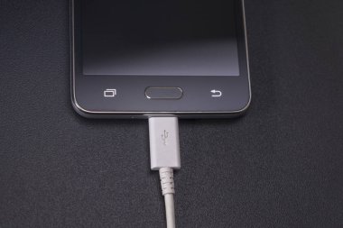 Beyaz kablo siyah zemin üzerine siyah smartphone