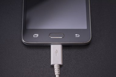 Beyaz kablo siyah zemin üzerine siyah smartphone