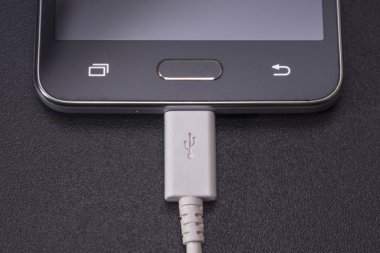 Beyaz kablo siyah zemin üzerine siyah smartphone