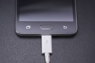 Beyaz kablo siyah zemin üzerine siyah smartphone