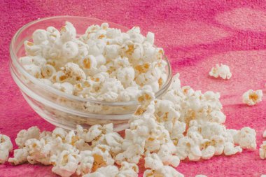 patlamış mısır pembe bir arka plan üzerine bir cam plaka