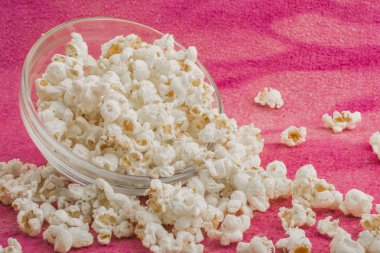 patlamış mısır pembe bir arka plan üzerine bir cam plaka