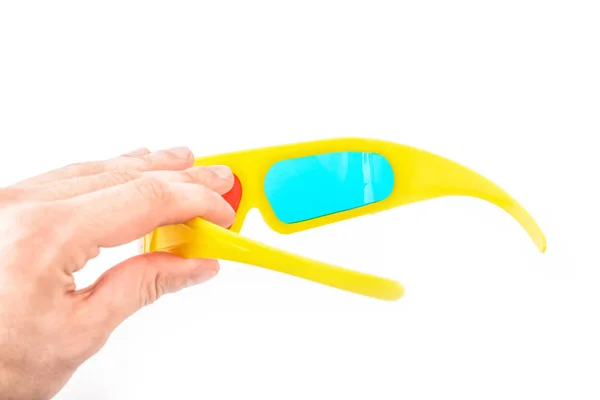 Желтые стерео очки в руке на белом фоне — стоковое фото