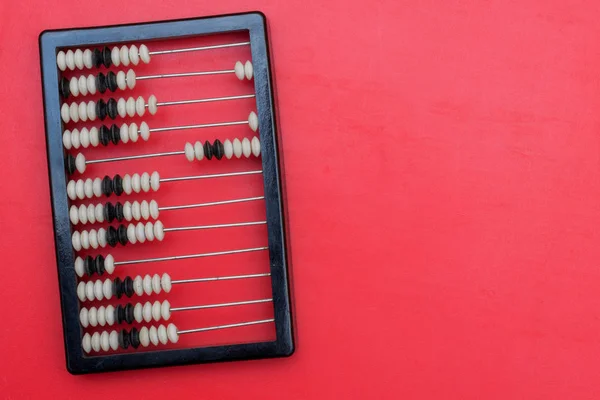 Ancient abacus with knuckles on a red background — Stock Photo, Image
