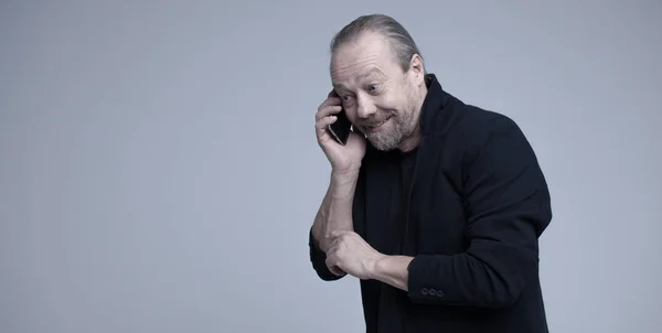 A cheerful, bearded, white man is talking on the phone. — Stock Photo, Image