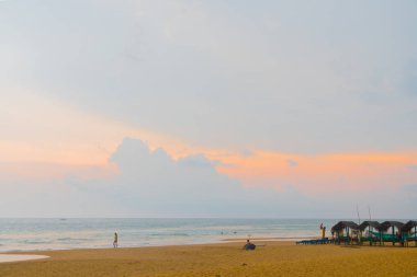 Okyanus dalgaları karşı mavi gökyüzü ve palmiye ağaçları.