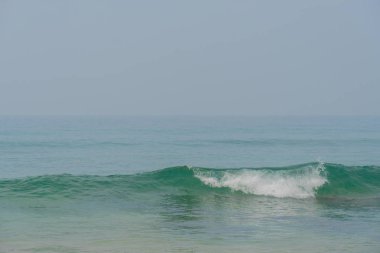 Mavi Dalgalar okyanus ve sarı kum plaj.