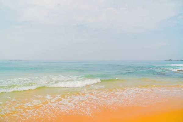 海洋的蓝色波浪和海滩的黄沙 — 图库照片