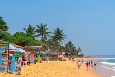 Mirissa, Sri Lanka, Asya 'da kumlu sahillerde gezinen turistler