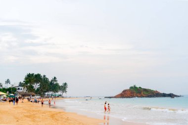 Mirissa, Sri Lanka, Asya 'da kumlu sahilde dinlenen turistler