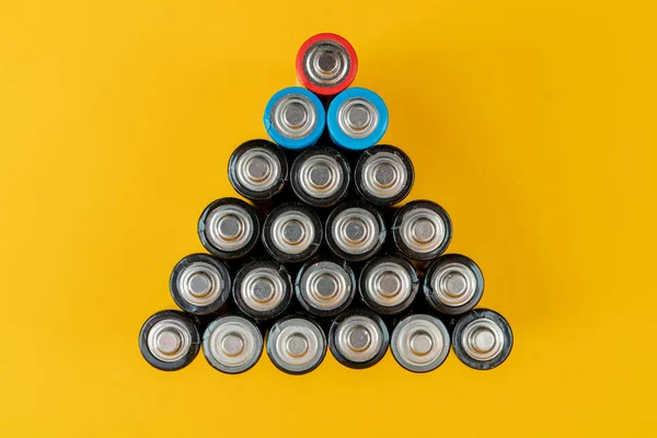 Used batteries are arranged in a triangle shape. Recycling and d — Stock Photo, Image