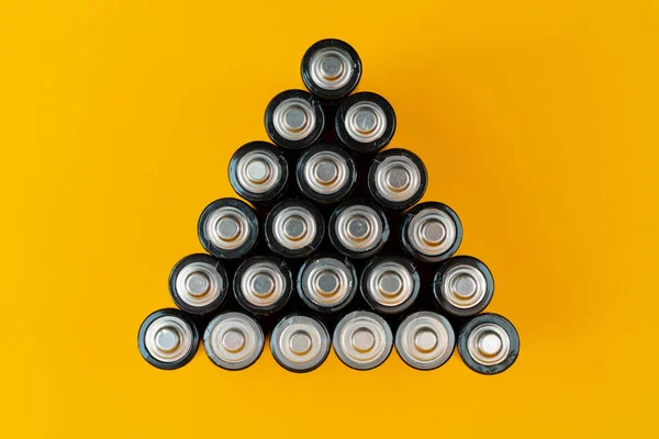 Used batteries are arranged in a triangle shape. Recycling and d — Stock Photo, Image