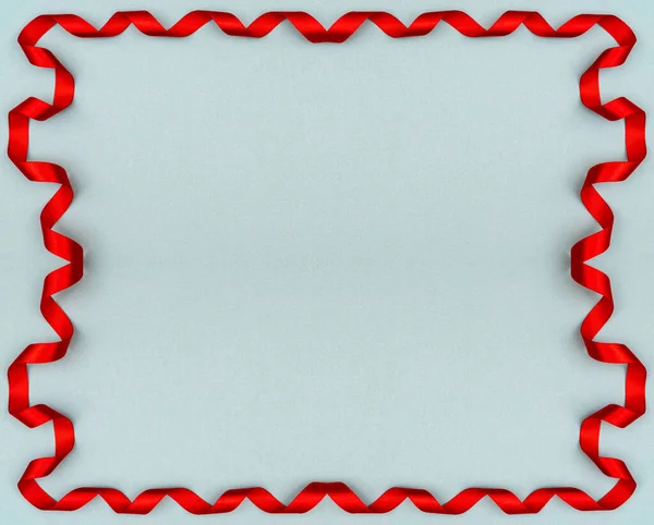 Κόκκινη κυματιστή κορδέλα σε μπλε φόντο. Διακόσμηση διακοπών. Βαλεντίν — Φωτογραφία Αρχείου