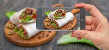 Taze ekmekler, sebze ve et. Fotoğraf akıllı telefon. Ukalâ.