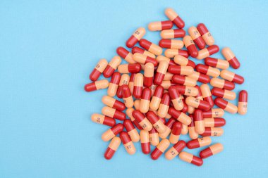 İlaç hapları ya da kapsüller mavi arka planda fotokopi alanı ile. İlaç tedavisi için ilaç reçetesi. İlaç, sağlık için konteynırda ilaç. Eczanede antibiyotik satışı.