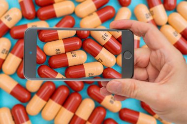 İlaç hapları ya da kapsüller akıllı telefon ekranında. İlaç tedavisi için ilaç reçetesi. İlaç, sağlık için konteynırda ilaç. Eczanede antibiyotik satışı.