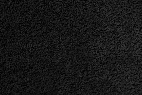 Abstract black background. Black stucco texture. Dark rough surface.