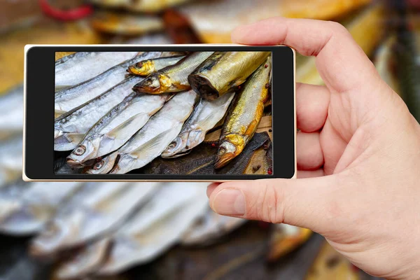 Smoked fish on smartphone screen. Seafood sale. Fish in shop window.
