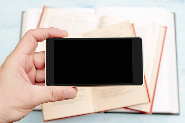 智能手机在男人的手中 现代小玩意手机 电话显示屏 旧纸质书 — 图库照片