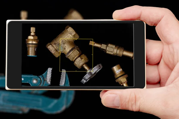 Plumbing tools on black background. Faucets, valve, pipe wrench to repair water supply system.