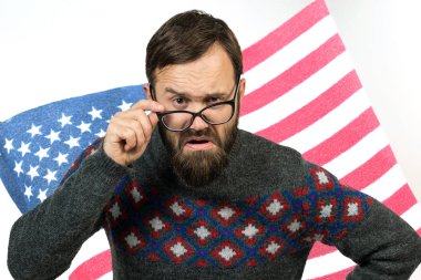 Amerikan bayrağının arka planında gözlüklü genç bir adamın portresi. Vatanseverlik kavramı