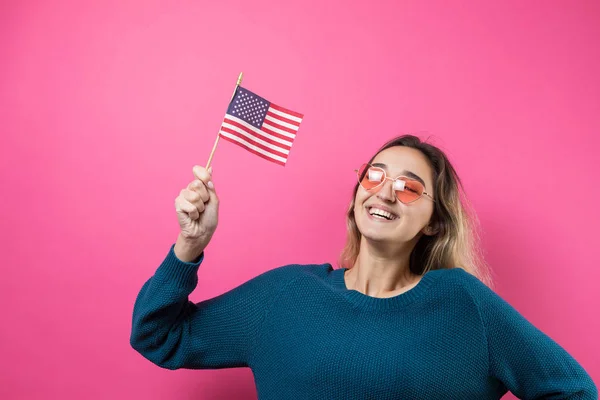 快乐的年轻女子心形眼镜 带着美国国旗 衬托着工作室粉色的背景 — 图库照片