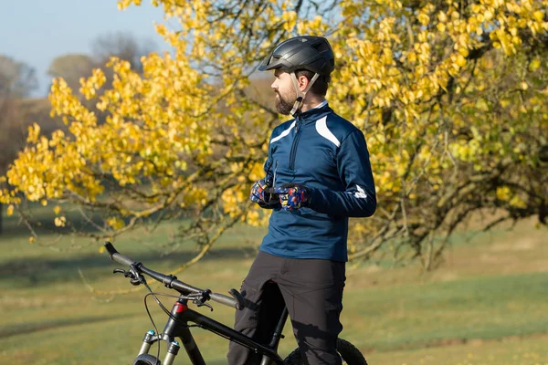 Cyclist in pants and fleece jacket on a modern carbon hardtail bike with an air suspension fork. The guy on the top of the hill rides a bike.