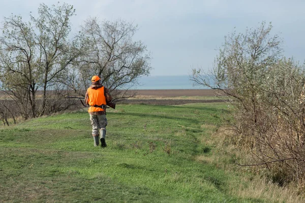 오렌지 조끼를 남자가 안개낀 날씨에 나무가 우거진 지역에서 사냥을 있었습니다 — 스톡 사진