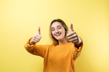 Turuncu süveter giyen güzel bir kızın portresi, düşünceli bir ifadeyle, daha ileri bir eylem planı düşünüyor..