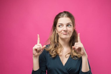 Pembe arka planda ciddi bir yüzü olan güzel bir genç kadının portresi.