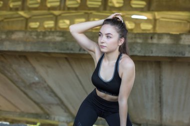 İnce atletik bir kız sabahın erken saatlerinde binanın arka planında derslere ara verip sessizliğin ve özgürlüğün tadını çıkarıyor..