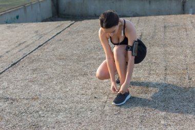 İnce atletik bir kız sabahın erken saatlerinde binanın arka planında derslere ara verip sessizliğin ve özgürlüğün tadını çıkarıyor..