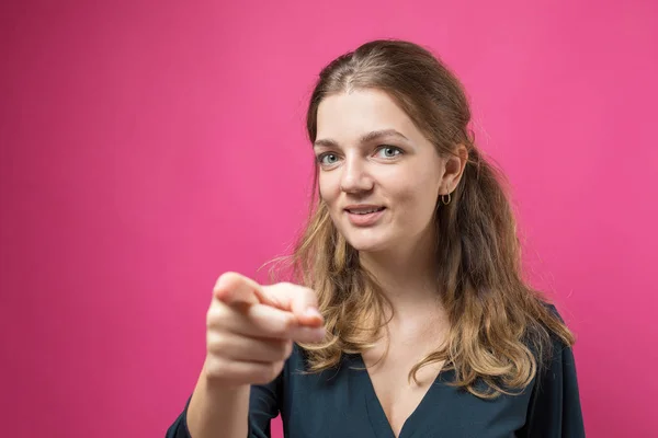 beautiful young woman with a serious face on a pink background