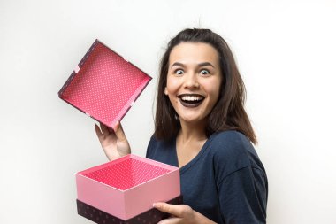 Beyaz arka planda hediye kutusu olan güzel genç bir kadın.