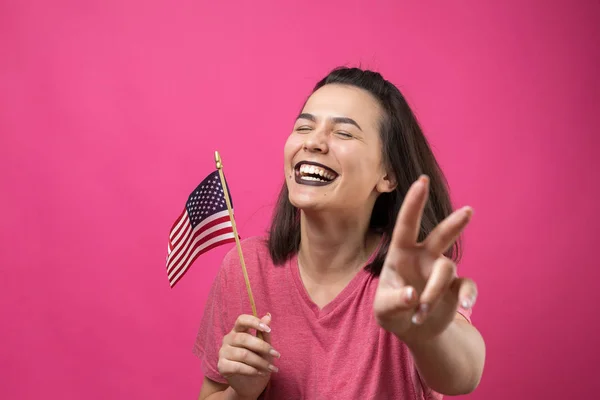 漂亮的年轻女子 粉红背景的美国国旗 — 图库照片