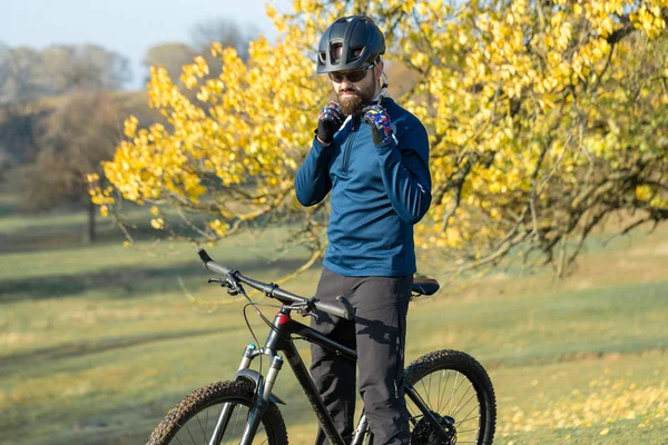 Cyclist in pants and fleece jacket on a modern carbon hardtail bike with an air suspension fork. The guy on the top of the hill rides a bike.