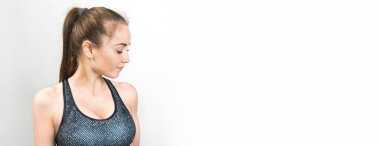 İnce atletik bir kız sabahın erken saatlerinde binanın arka planında derslere ara verip sessizliğin ve özgürlüğün tadını çıkarıyor. Panoramik resim, tonlanmış.