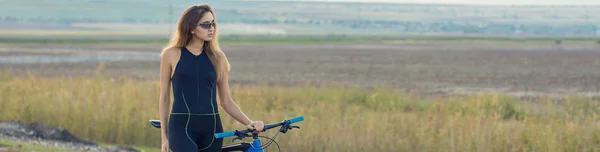 young woman with bike walking outdoors