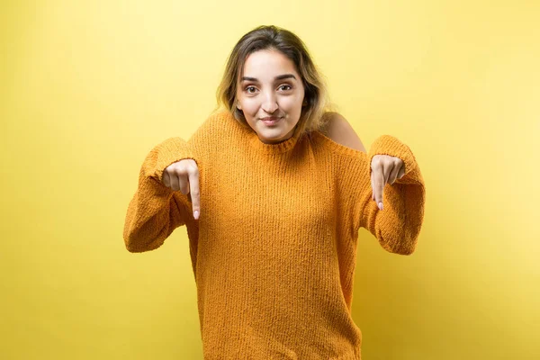 Jovem Mulher Caucasiana Feliz Uma Camisola Laranja Apontando Dedos Distância — Fotografia de Stock