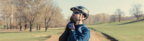 眼鏡とヘルメットのアスリートの若い男は 距離を調べる トーンパノラマ画像 — ストック写真