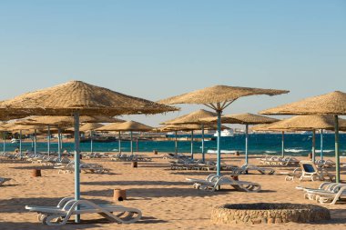 Kumlu sahilde şemsiyesi ve şemsiyesi olan güzel bir sahil.