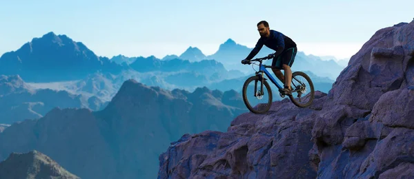 Conquering mountain peaks by cyclist in shorts and jersey on a modern carbon hardtail bike with an air suspension fork . Beautiful view from the mountain. Panoramic view for banner.