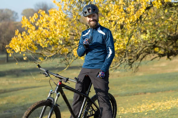 Cyclist in pants and fleece jacket on a modern carbon hardtail bike with an air suspension fork. The guy on the top of the hill rides a bike.