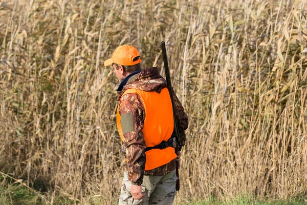 Een Man Met Een Pistool Zijn Handen Een Oranje Vest — Stockfoto