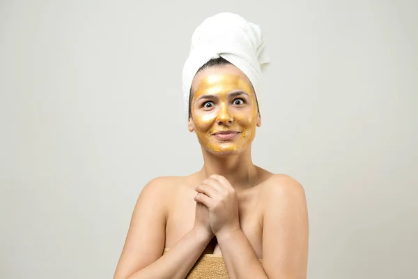 头戴白色毛巾 脸上戴金色营养面罩的女人的美丽画像 瘦身清洁生态有机化妆品温泉放松概念 — 图库照片