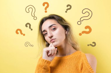 Sarı arka planda güzel bir kızın portresi, soru işaretleriyle dolu, düşünceli bir ifadeyle yan yana duran, daha ileri bir eylem planı düşünüyor..