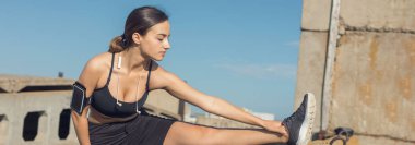 İnce atletik bir kız gün batımında güzel gökyüzünün arka planında dersler arasında sessizlik ve özgürlüğün tadını çıkarıyor..