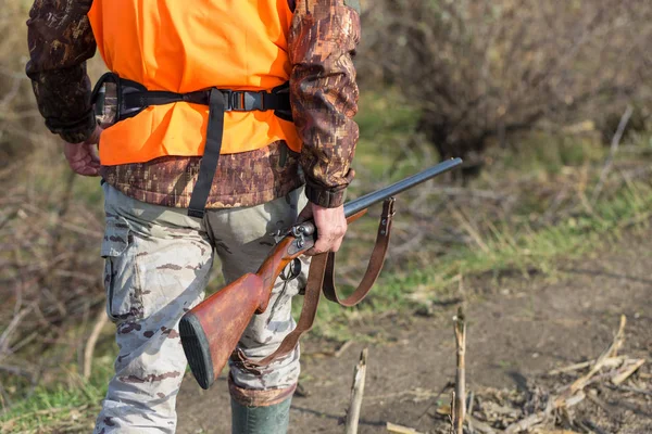 Een Man Met Een Pistool Zijn Handen Een Oranje Vest — Stockfoto