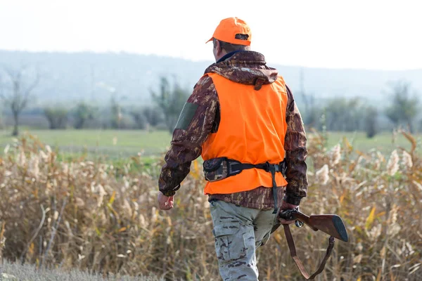 Een Man Met Een Pistool Zijn Handen Een Oranje Vest — Stockfoto