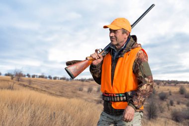 Avlanırken av sırasında av hayvanı ya da av hayvanı arayan kamuflajlı bir avcı. Sonbahar av sezonu.